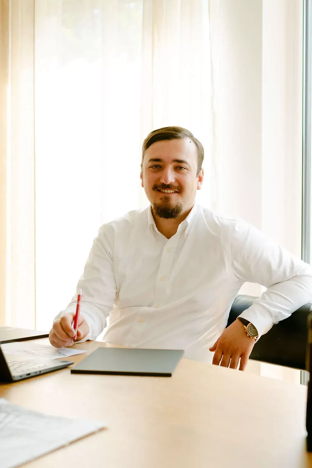 Rouven Reimann am Schreibtisch mit Stift in der Hand